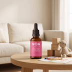 בקבוק NOA OpenHeart™ 30 מ"ל על שולחן עם צעצועי עץ