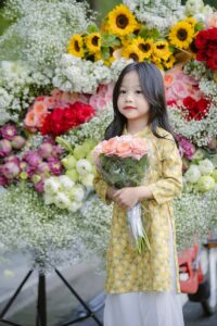 Portrait of Girl in Traditional Clothing and with Flowers Bouquet
