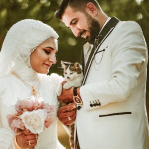 A muslim bride and groom holding a cat