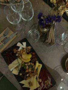 A table with a plate of food and wine glasses