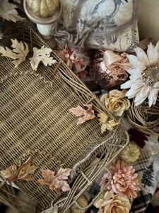 A basket with flowers and leaves on top of it