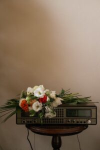 A radio with flowers on top of it