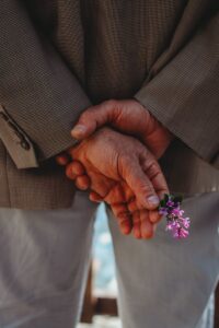 Back View of a Senior Man Holding Flower in Hand